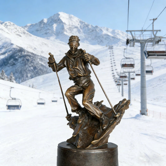 This is a dynamic bronze sculpture of a skier, crafted using the lost-wax casting method. The piece captures the athlete mid-action, navigating a rugged, snow-like terrain with ski poles firmly in hand and legs bent in a powerful stance. The rich, warm bronze patina accentuates the fluid folds of the skier’s jacket and pants, as well as the textured, naturalistic base that simulates a snow-covered slope.