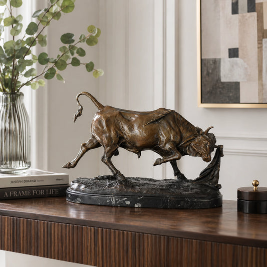 Detailed bronze bullfight scene sculpture with charging bull and matador cape, realistic animal anatomy statue on veined black marble base, loss wax casting fine art.