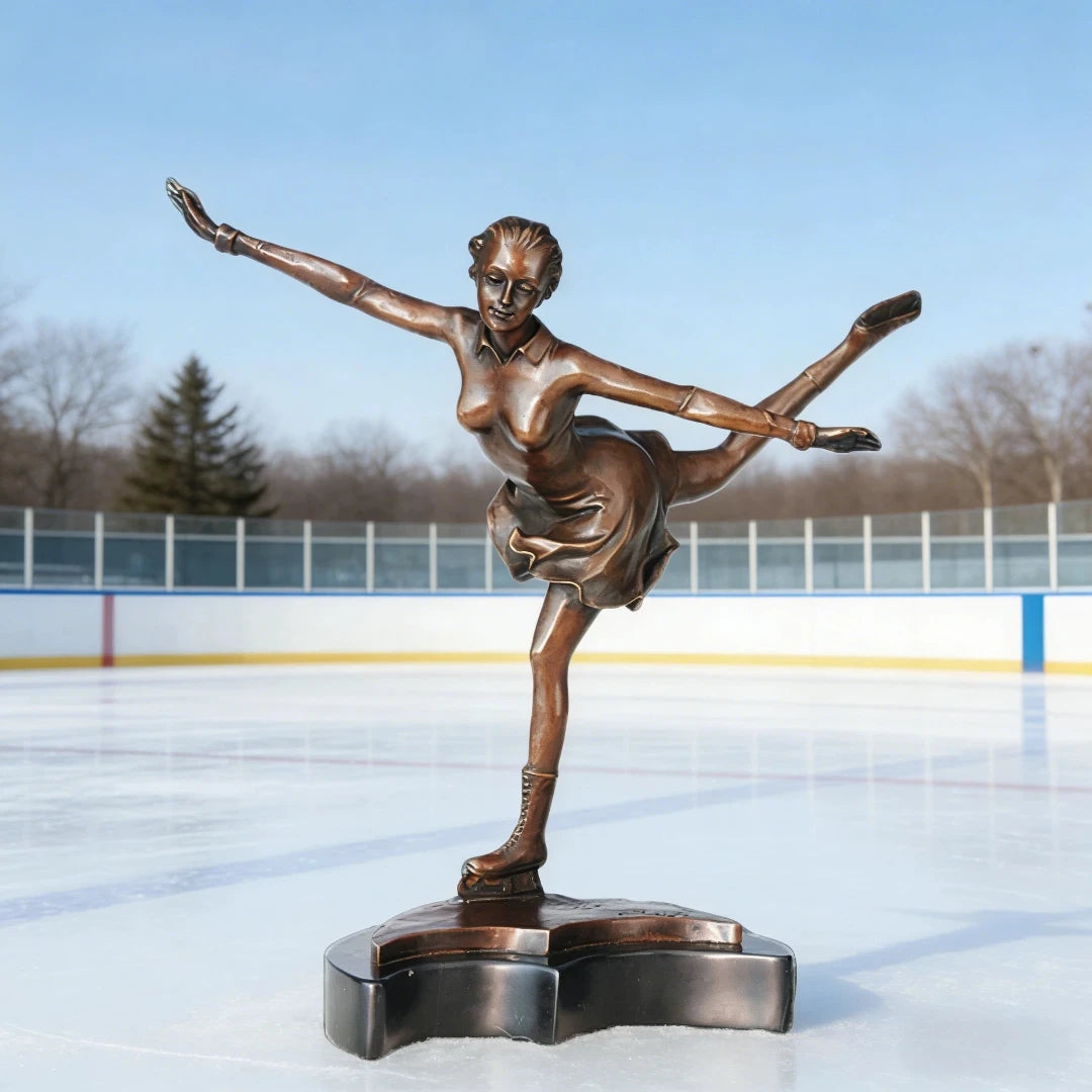 This is an elegant bronze sculpture of a figure skater, crafted using the lost-wax casting method. The piece captures the athlete mid-performance, striking a graceful pose with one leg extended high behind her and arms outstretched, conveying poise, balance, and fluid movement. The rich, warm bronze patina accentuates the delicate folds of her dress, the intricate details of her ice skates, and the smooth, flowing lines of her form.