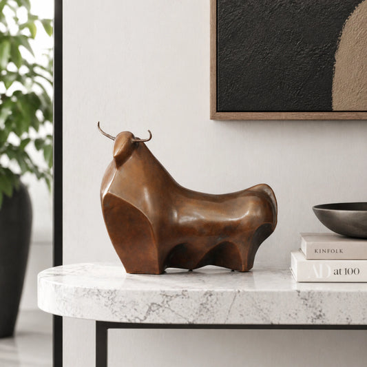 Minimalist abstract bronze bull sculpture with rounded geometric forms, stylized modern bull statue on black marble base, loss wax casting contemporary art.