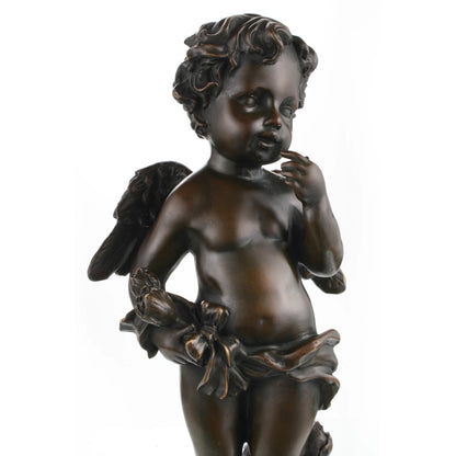 Bronze cherub cupid statue with wings on marble base.Close-up of cherub face and expression in bronze