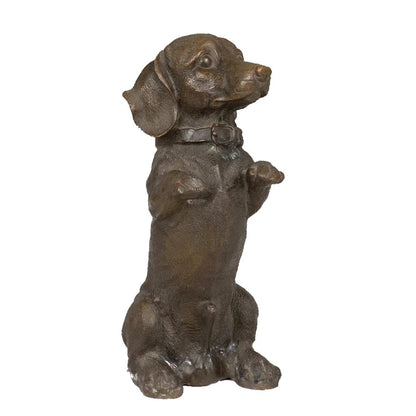 This charming bronze dachshund sculpture is crafted using the traditional lost-wax casting method, capturing the dog in a playful seated pose with its front paws raised. The warm bronze patina highlights its distinctive long body, short legs, floppy ears, and detailed collar. With an integrated bronze base for stability, this piece combines realism with whimsical character, making it a delightful accent for home decor or a thoughtful gift for dachshund lovers.