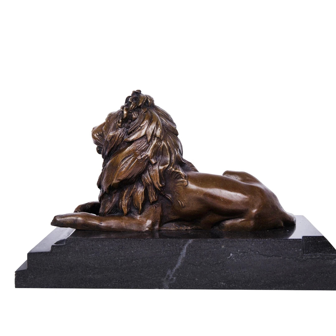 This majestic bronze lion sculpture, crafted using the lost-wax casting method, captures the animal in a poised, reclining stance. The rich bronze patina highlights the lion’s powerful musculature and flowing mane, while its elevated head and relaxed posture convey quiet authority and regal composure. Mounted on a stepped dark marble plinth, the sculpture exudes stability, grandeur, and timeless elegance, making it ideal for refined interiors or as a distinguished art collection piece.