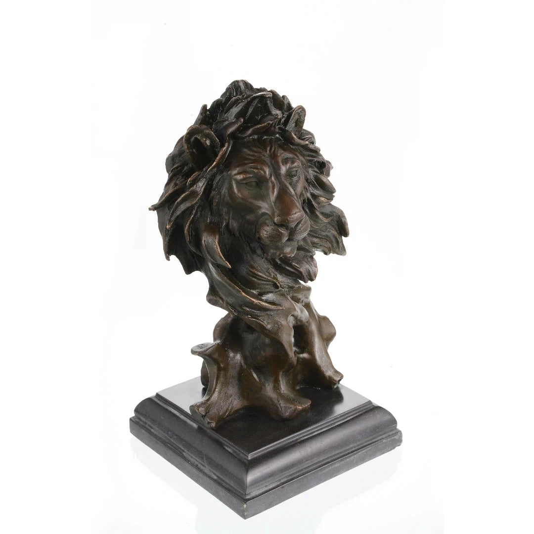 This is a striking bronze bust of a lion, crafted using the lost-wax casting method. The sculpture focuses on the lion’s head and upper neck, capturing the animal in a moment of quiet intensity, with its mane rendered in dynamic, flowing forms that suggest movement and raw power. The deep, rich bronze patina accentuates the intricate details of the lion’s facial features—from the intense gaze of its eyes to the texture of its whiskers—and the dramatic, almost wind-swept folds of its mane.