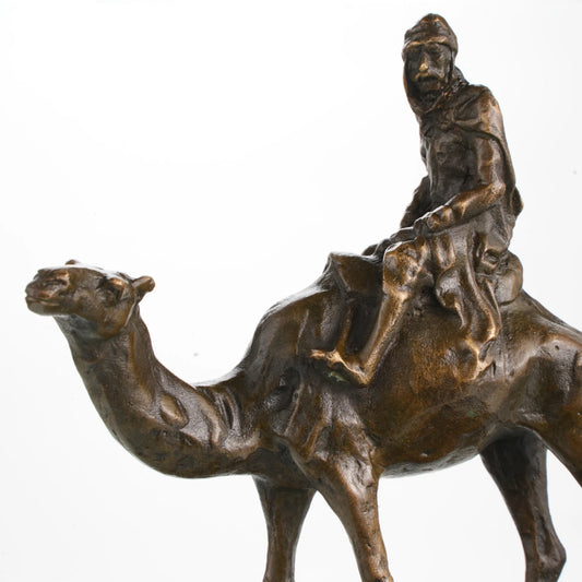 Solid bronze Bedouin desert traveler on camel sculpture, Orientalist art on dark marble base, rugged office decor for travelers.