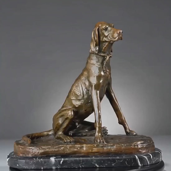 This is a stately bronze sculpture of a seated pointer dog, crafted using the lost-wax casting method. The piece captures the dog in an alert, upright seated pose, with its head turned slightly to the side, conveying a sense of keen focus and elegant poise typical of a hunting breed. The rich, warm bronze patina accentuates the dog’s lean, muscular physique, the smooth texture of its short coat, and the delicate details of the rope collar around its neck.