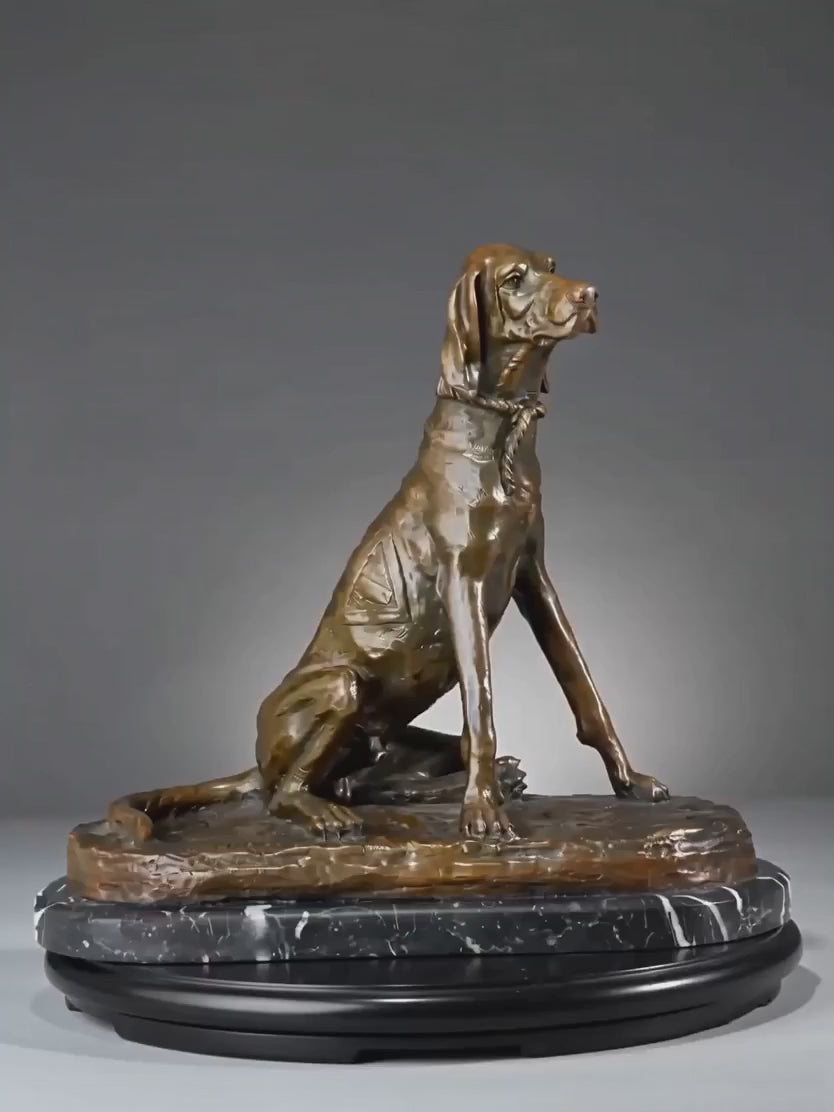 This is a stately bronze sculpture of a seated pointer dog, crafted using the lost-wax casting method. The piece captures the dog in an alert, upright seated pose, with its head turned slightly to the side, conveying a sense of keen focus and elegant poise typical of a hunting breed. The rich, warm bronze patina accentuates the dog’s lean, muscular physique, the smooth texture of its short coat, and the delicate details of the rope collar around its neck.