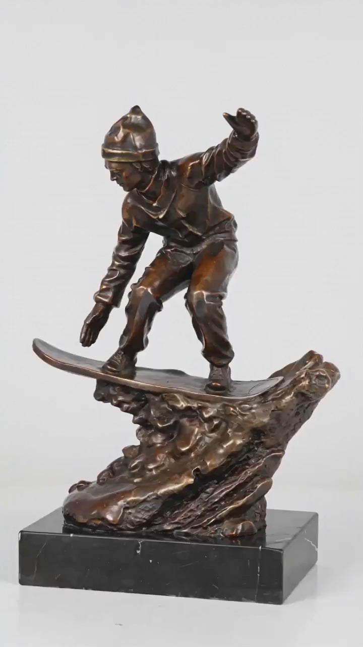 This is a dynamic bronze sculpture of a snowboarder, crafted using the lost-wax casting method. The piece captures the athlete mid-action, crouched low on their board while navigating a rugged, snow-like terrain, with one arm extended for balance. The rich, warm bronze patina accentuates the fluid folds of the snowboarder’s jacket and pants, as well as the textured, naturalistic base that simulates snowdrifts.