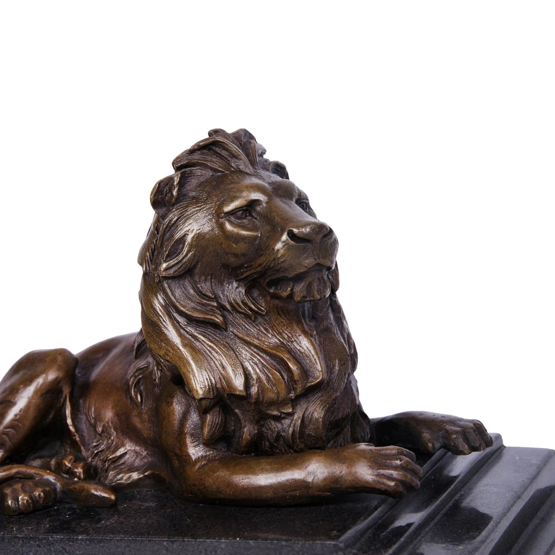 This majestic bronze lion sculpture, crafted using the lost-wax casting method, captures the animal in a poised, reclining stance. The rich bronze patina highlights the lion’s powerful musculature and flowing mane, while its elevated head and relaxed posture convey quiet authority and regal composure. Mounted on a stepped dark marble plinth, the sculpture exudes stability, grandeur, and timeless elegance, making it ideal for refined interiors or as a distinguished art collection piece.