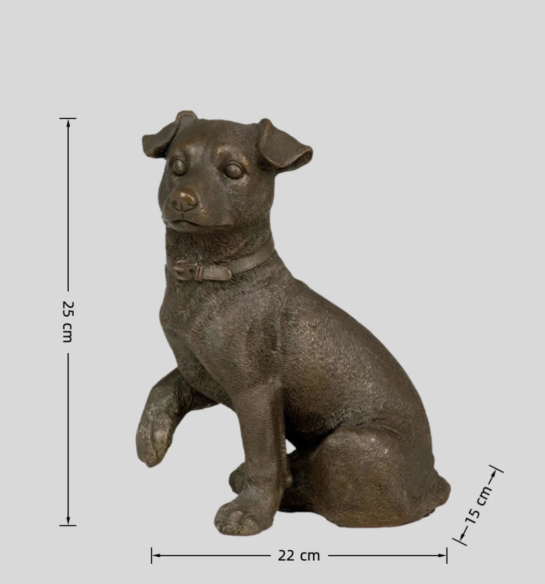 This is a lifelike bronze sculpture of a terrier dog, crafted using the lost-wax casting method. The piece captures the dog in a seated pose, with one front paw gently raised, conveying a sense of alert curiosity and endearing attentiveness. The rich, warm bronze patina accentuates the detailed, short, textured coat, the expressive eyes, and the buckle on its leather collar.